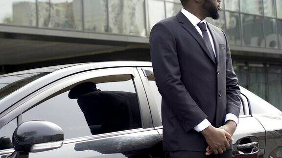 私人司机和保镖站在车旁等待富有的vip客户