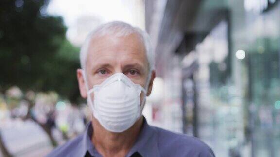 一名白人男子戴着口罩在街上走动以抵御冠状病毒