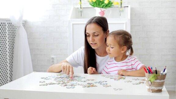 母亲和女儿在明亮的客厅里拼拼图