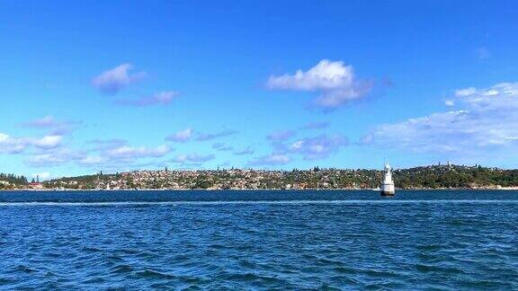 悉尼港前海岸上一片阴云密布的天空从前往曼利的渡轮上看你可以看到公寓、豪华住宅、游艇、海滩和悬崖