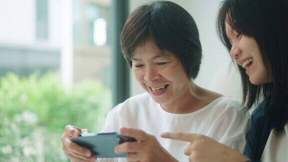 一位年长的女士正在用她的智能手机玩游戏