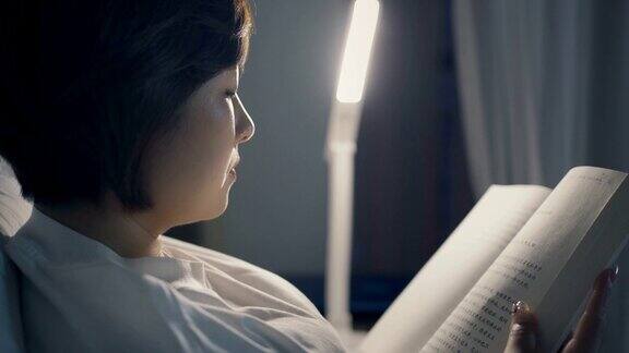 晚上躺在床上看书的亚洲女人