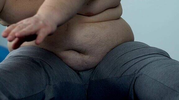 胖男人用肥胖的皱褶伸展努力够到脚趾减肥的愿望