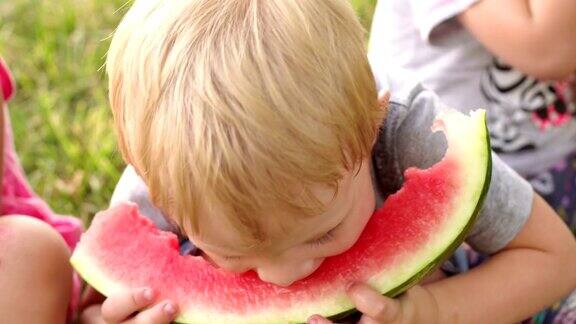 夏天一个小男孩在公园里吃西瓜