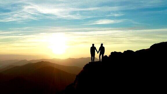 这对夫妇站在山上看美丽的日出