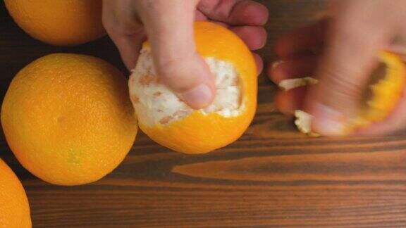男性手剥橘子柑桔水果在木制背景俯视图