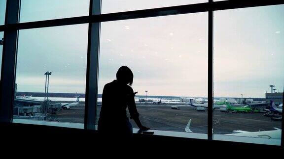 在机场候机楼等飞机的女人