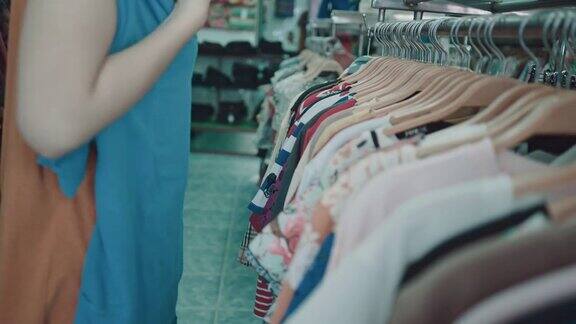 亚洲女人在购物中心挑选衣服