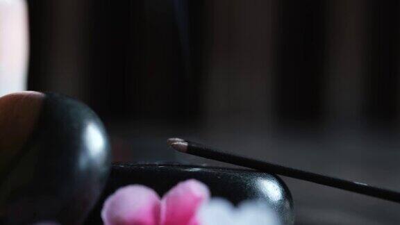 按摩石和蜡烛特写在一个木制的黑色背景