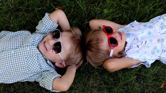 两个好玩的小孩4岁在夏天的草地上休息