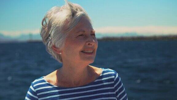 微笑的老妇人在度假中驾驶游艇