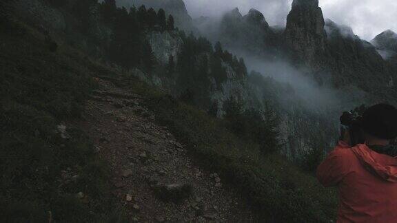 男子摄影师徒步旅行在一个寒冷的雾蒙蒙的日落高山白云石