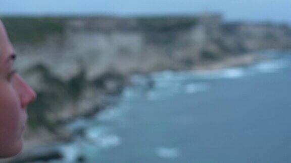 科西嘉海岸上的年轻女子在悬崖和海浪的慢镜头中