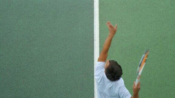 一个年轻人打网球的特写镜头以慢动作发球