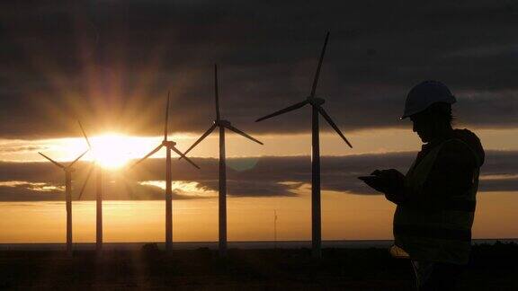 可再生能源系统黄昏时分电力维护工程师在一个风力发电站的现场工作