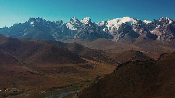 鸟瞰风景山荒野山谷与高峰和冰川河流在吉尔吉斯斯坦