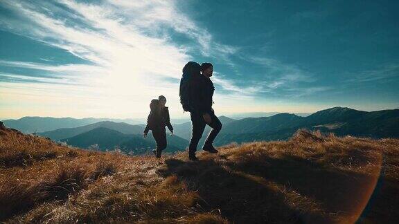 在阳光明媚的背景下这对夫妇在山上散步慢动作
