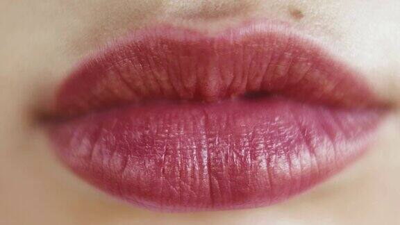 闭上红色的嘴唇一个女人的脸与明亮的红色口红在她的嘴唇上的特写