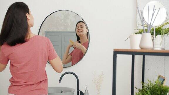 漂亮女学生梳头看浴室镜子的慢镜头
