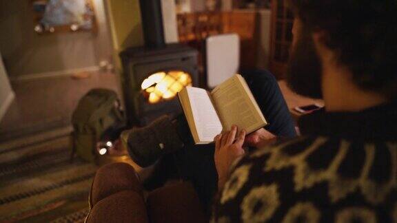 在舒适的小屋里一个人坐在火炉旁看书
