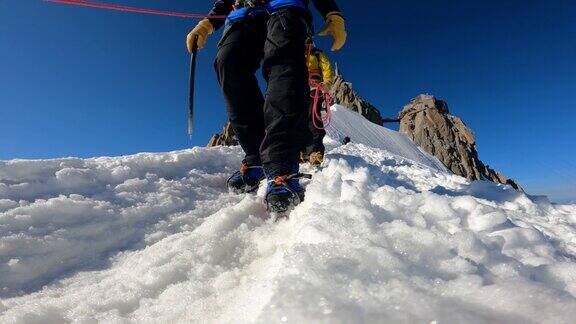 高级登山队正在向欧洲阿尔卑斯山积雪覆盖的山峰进发靠近腿部