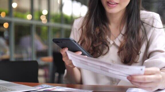 年轻女子用智能手机在线支付账单