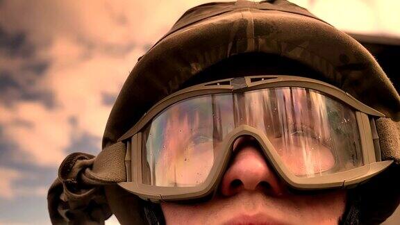 特写脸的白种士兵在头盔与天空和阳光反射眼镜向前看希望和平静的生活真实