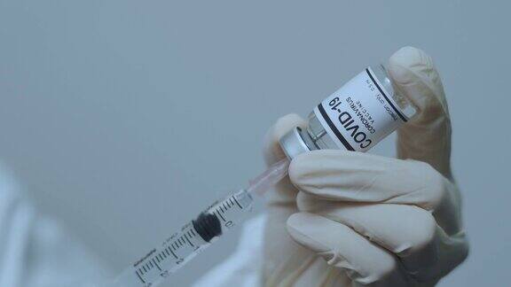 医生手持注射器和Covid-19疫苗瓶