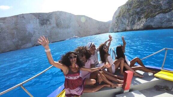 4K视频无人机观看的朋友享受夏季度假在Zakynthos希腊-Navagio海滩上的船