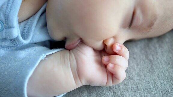 可爱的小男孩把手指放在嘴里睡觉