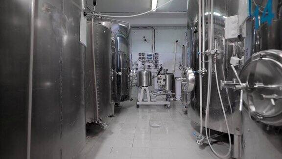 工作日发酵缸站在现代啤酒厂的干净车间里摄像头向后移动