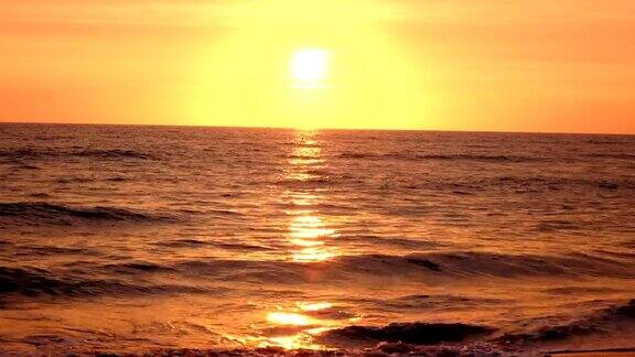 在夕阳的照耀下海浪在沙滩上翻滚