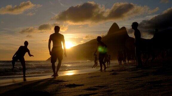 日落时分在巴西伊帕内玛海滩踢沙滩足球