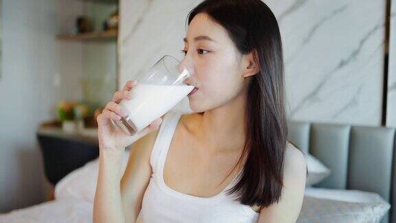 喝牛奶的亚洲年轻女子早上下班之前