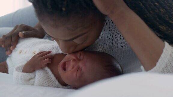 一位非洲裔单亲妈妈的爱在家里亲吻她刚出生的孩子一个哺乳婴儿的母亲怀孕和生育