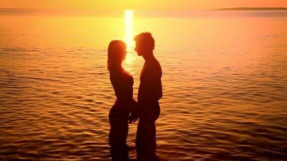 一对情侣在日落时接吻的剪影