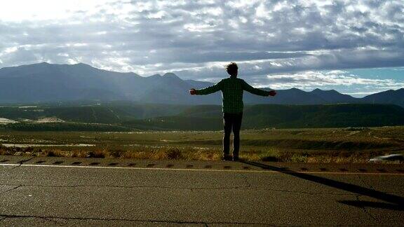 30岁的年轻人旅行者和博主在美国科罗拉多州的山区高速公路上拍摄风景