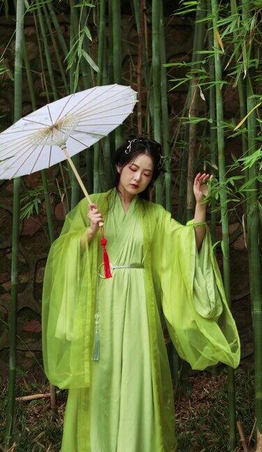 一位身着汉服的美女在竹林里打着油纸伞