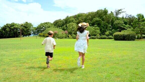 日本男孩和女孩在蓝天下奔跑