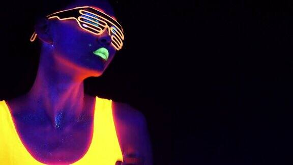 迷人的视频性感的网络raver女人拍摄在荧光衣服下的紫外线黑光性感的女孩网络发光raver妇女拍摄在紫外线黑光下荧光服装派对