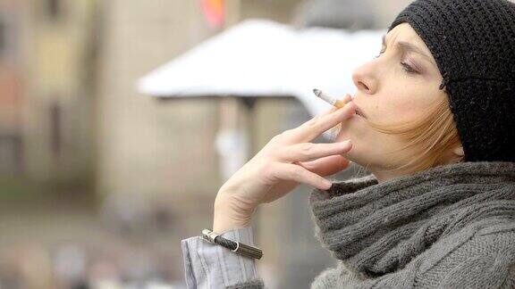 一个悲伤的年轻女人在街上吸烟的特写:孤独