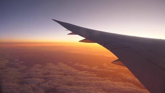 客机飞向日出机翼和窗外的天空