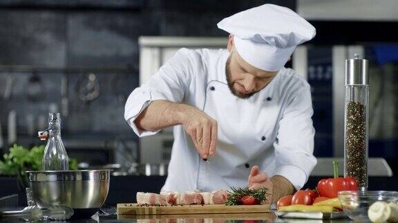 男厨师在厨房用慢动作腌制肉专业男士烹饪菜