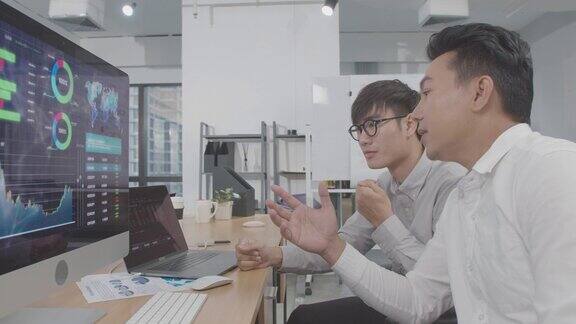 4K分辨率视频两位亚洲商人用电脑讨论和分析财务数据投资分析财务数据概念亚洲办公室室内商务生活