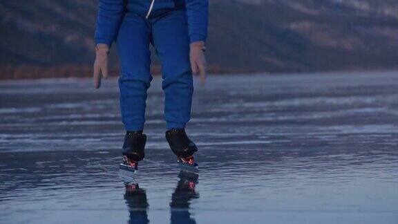 这个女孩在冰上进行速度滑冰训练孩子们冬天溜冰穿着蓝色运动服戴着运动眼镜孩子们进行速滑运动