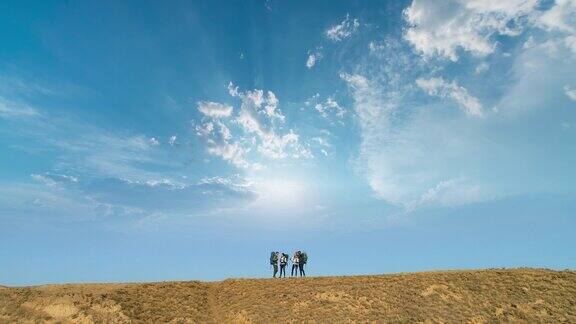 四个旅行者站在山顶上