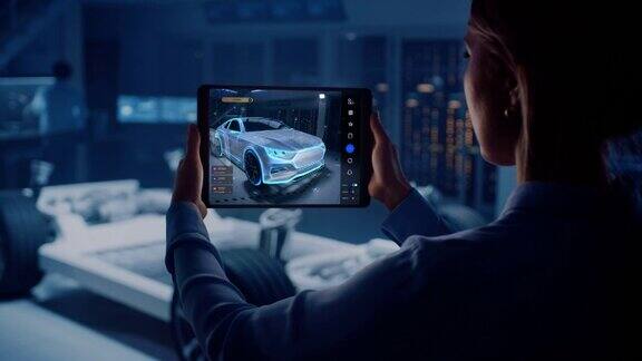 汽车工程师在电动汽车底盘平台工作使用平板电脑与增强现实3D软件创新设施:车轮车辆框架成为视觉特效虚拟模型