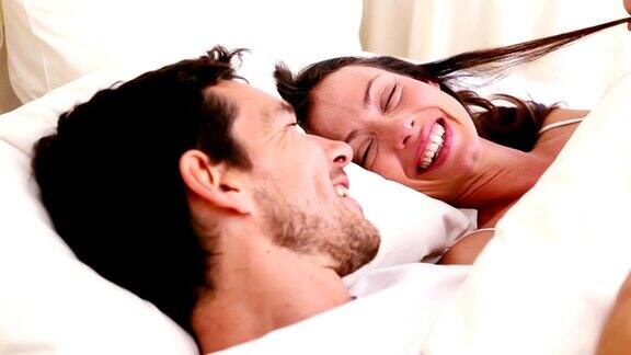 一对幸福的夫妇躺在床上聊天