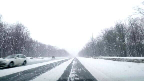 在下雪的乡村道路上驾驶POV冬季雪山公路驾驶森林开车