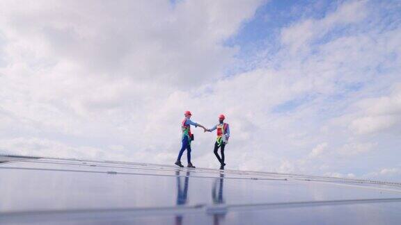 成功的团队技术人员在工厂屋顶安装和维护太阳能电池板